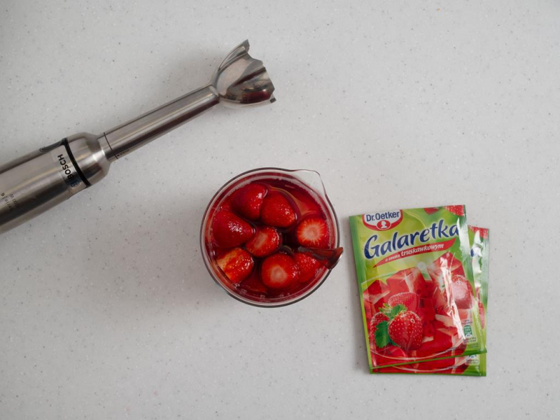 galaretka z truskawkami w naczyniu obok ręczny blender