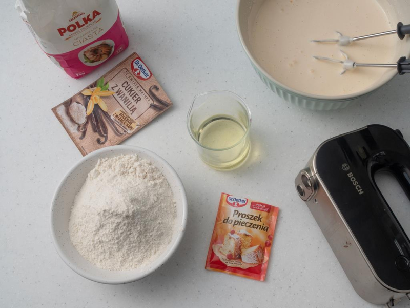 w misce ubite jajka, obok mąka, cukier z wanilią Dr. Oetkera i mikser ręczny