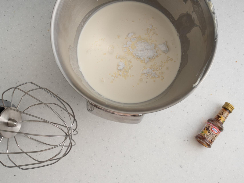 W misie śmietanka, mascarpone i cukier puder. Obok ekstrakt waniliowy.