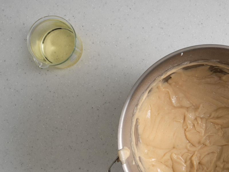 Olej w szklance. Obok w misie surowe ciasto.