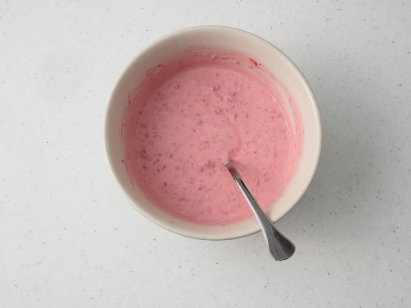 w misce wymieszany jogurt z malinami