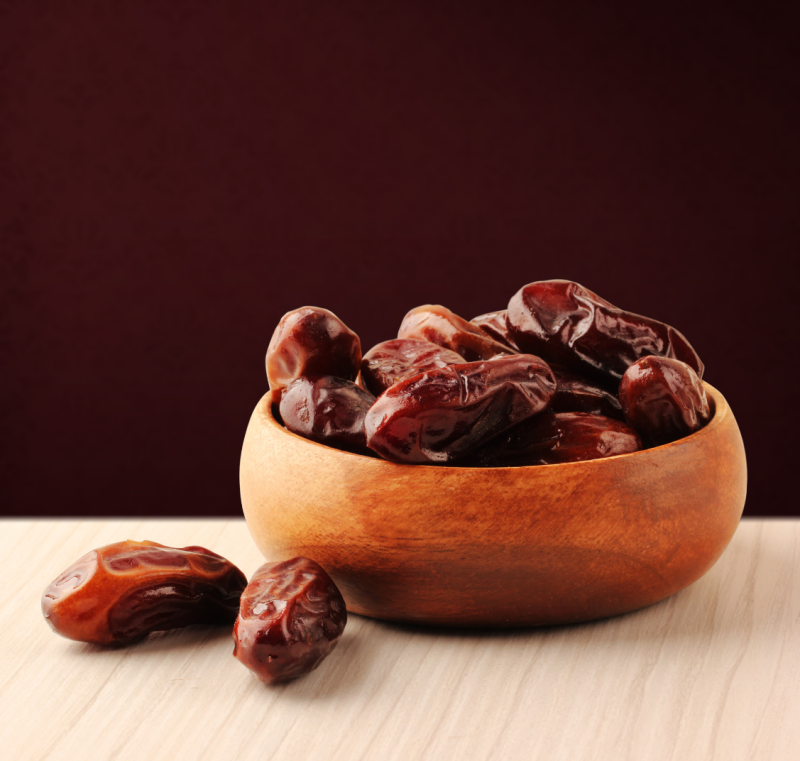 drewniana miseczka wypełniona daktylami