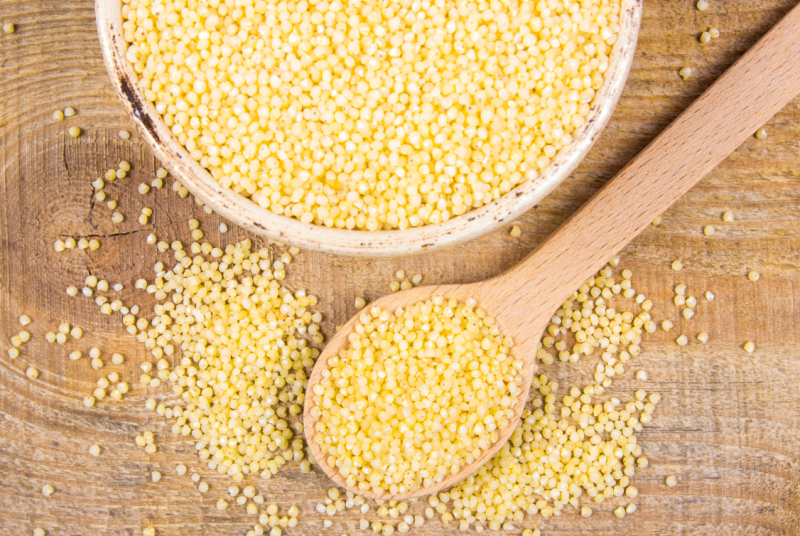 kasza jaglana w miseczce i na drewnianej łyżce