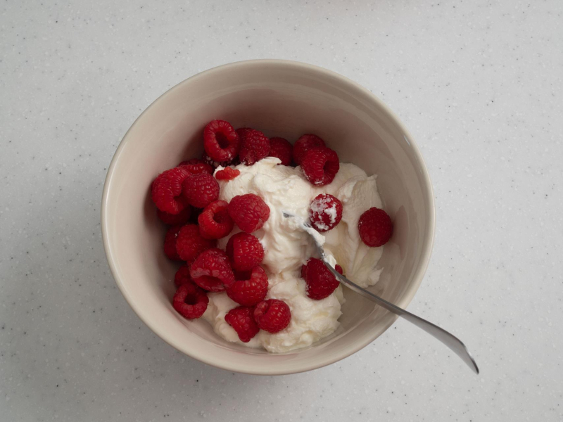 w miseczce maliny i jogurt grecki