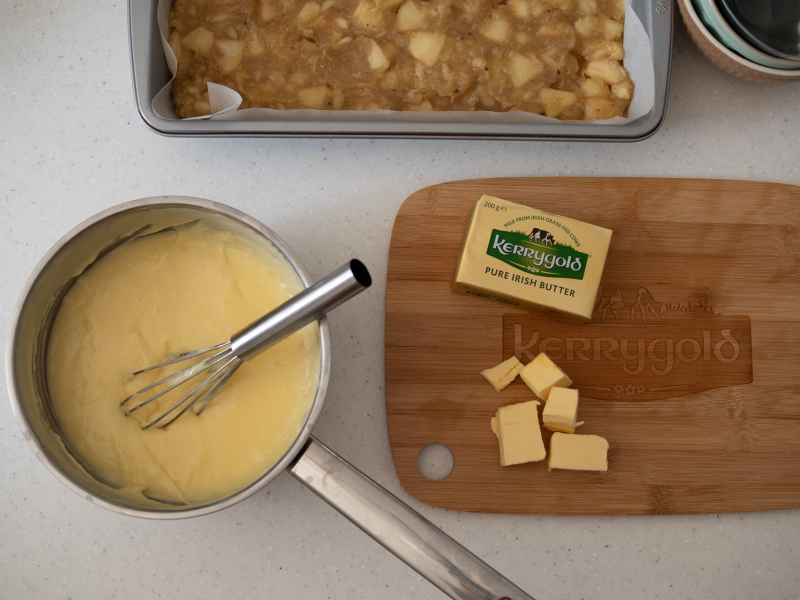na desce pokrojone masło kerrygold obok w rondelku ugorowany budyń