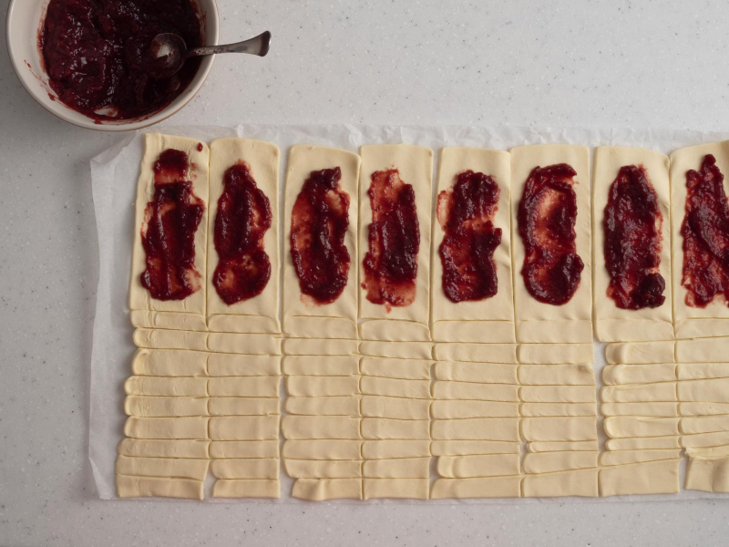 Dżem malinowy rozsmarowany na cieście francuskim.