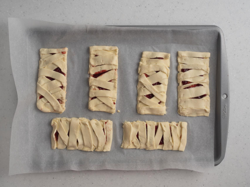 Ciasteczka mumie z ciasta francuskiego przed pieczeniem.