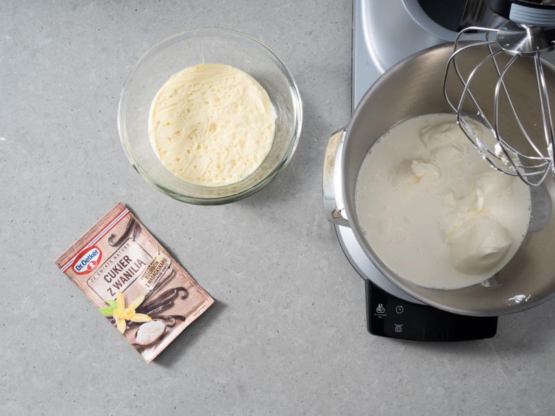 Na blacie kuchennym cukier z wanili膮. Obok ganache z bia艂ej czekolady i 艣mietanka z mascarpone w misie miksera.