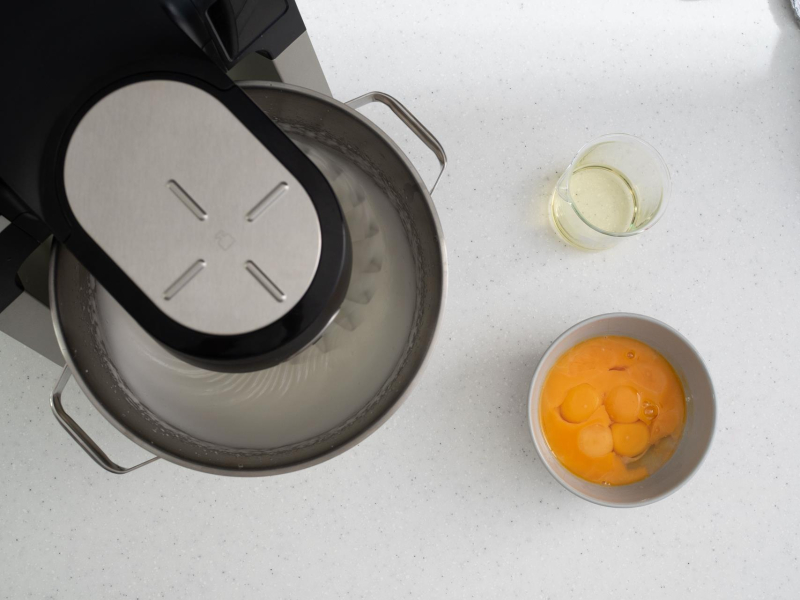 Ubijanie białek w mikserze. Obok w miseczce żółtka oraz olej.