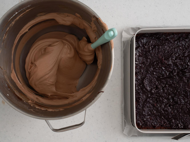 Gotowa masa truflowa. Obok blat ciasta posmarowany dżemem porzeczkowym.