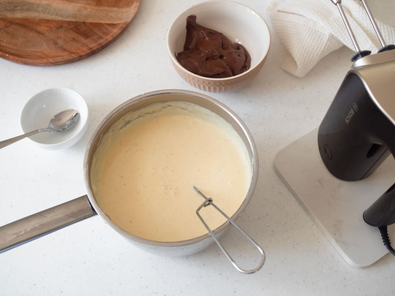 rondel z budyniem, obok w miseczce nutella i mikser ręczny bosch