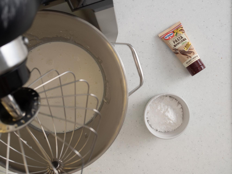 Ubita śmietanka z cukrem pudrem i pastą waniliową.