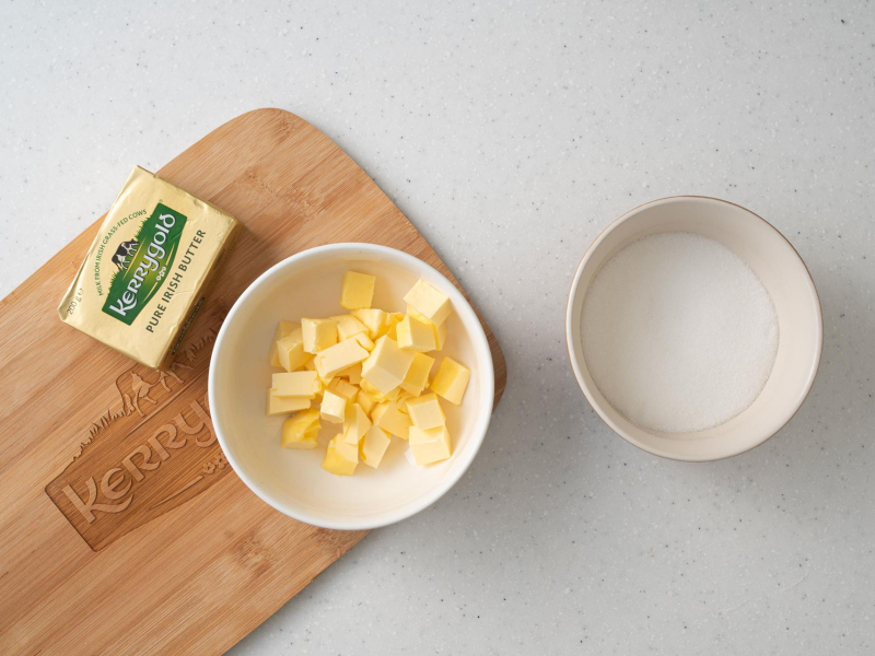 Miękkie masło w miseczce. Obok cukier w misce.