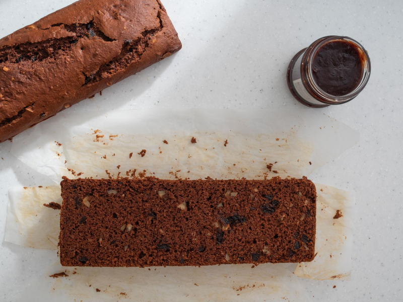 Przekrojony piernik pomidorowy, a obok powidła śliwkowe.