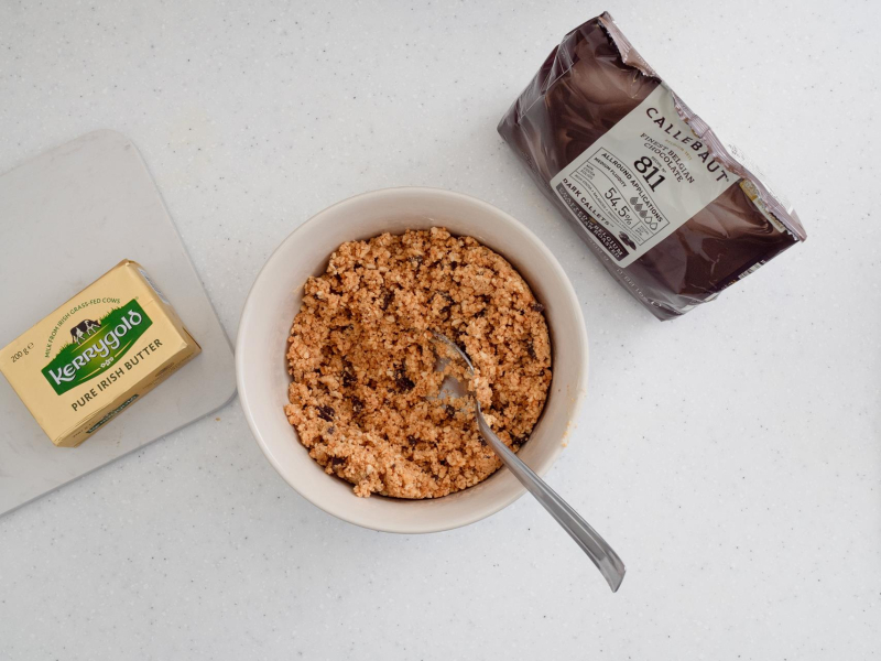 w miseczce pokruszone ciasteczka z masłem na ciasteczkowy spód