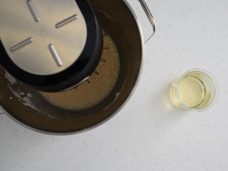 Surowe ciasto w misie, a obok olej w szklance.