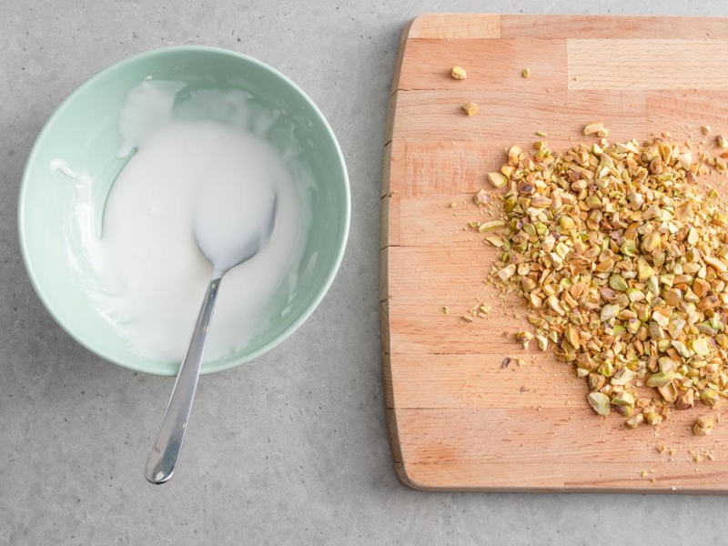 w miseczce lukier, na desce posiekane pistacje