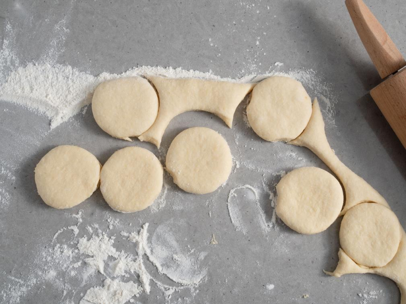 na blacie wycięte kółka ciasta drożdżowego na pączki