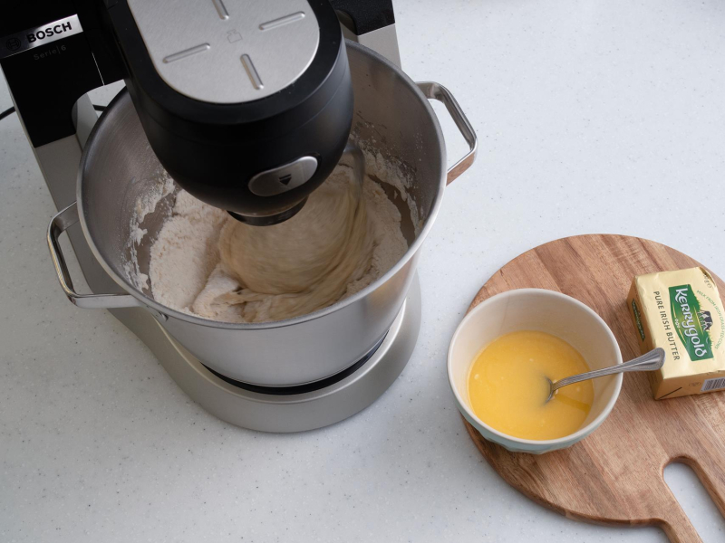 zagniatane ciasto drożdżowe, na desce drewnianej roztopione masło Kerrygold