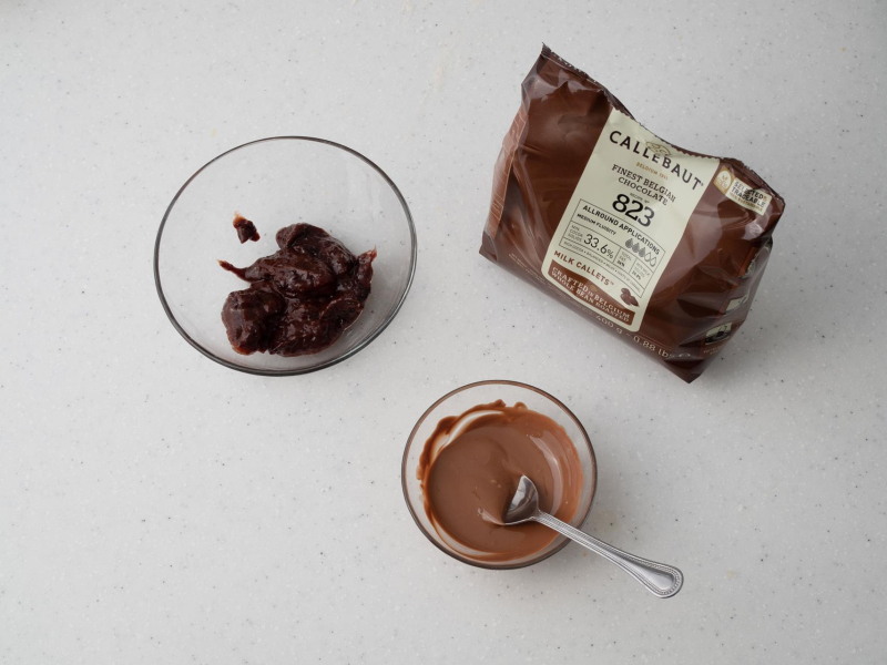 w miseczce roztopona czekolada Callebaut i miseczka z powidłami śliwkowymi