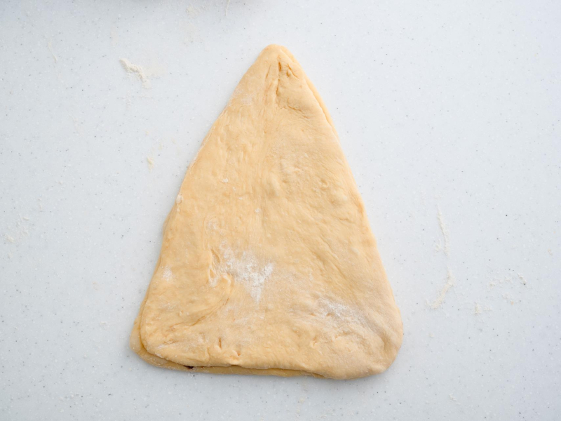 rozwałkowane ciasto drożdżowe w kształcie trójkąta