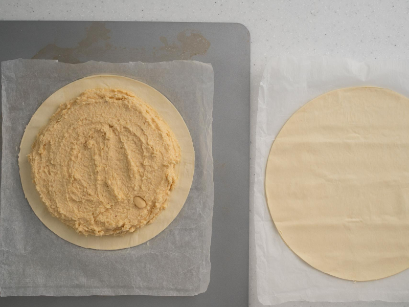 Masa migdałowa nałożona na jeden z placków ciasta.