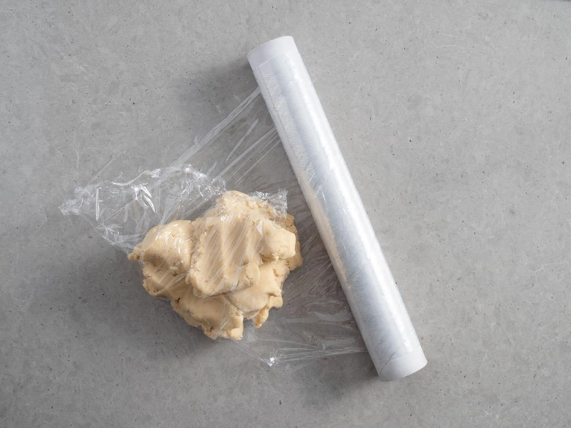 porcja surowego kruchego ciasta owinięta w folię spożywczą