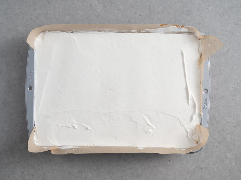 W blaszce ciasto wyłożone kremem śmietankowym na wierzchu