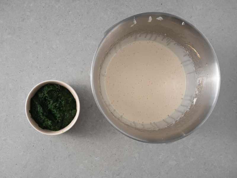 W misie utarte jajka z cukrem i olejem, a obok w miseczce rozdrobniony szpinak.