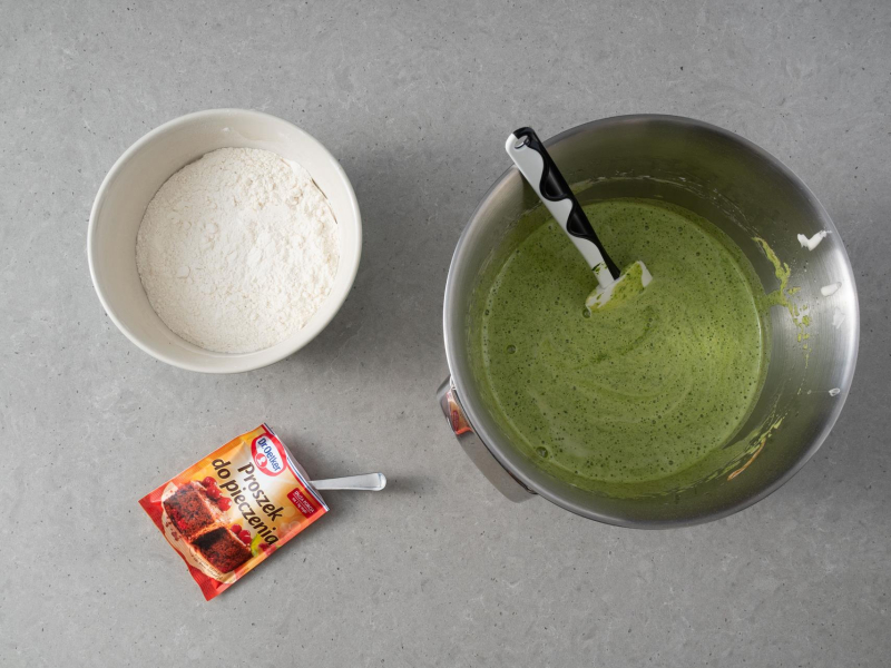 Na blacie kuchennym misa z ciastem ze szpinakiem. Obok m膮ka pszenna w misce i proszek do pieczenia Dr. Oetkera.