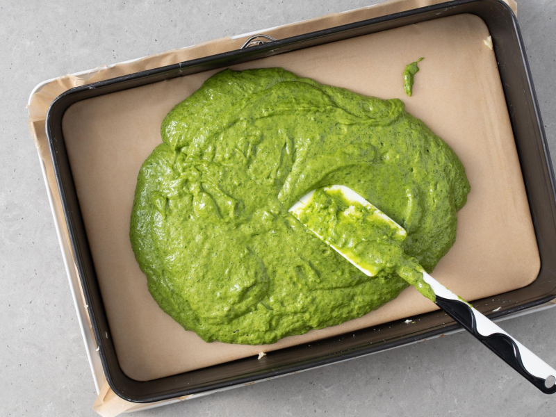 Rozsmarowywanie ciasta szpinakowego na du偶ej blasze,