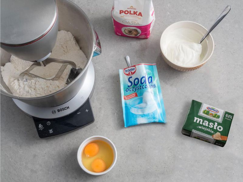 w misie robota mąki i na blacie masło, soda Dr. Oetker