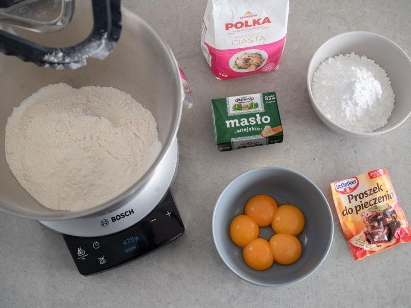 w misce robota bosch mąka Polka, na blacie masło Kerrygold, cukier puder i proszek do pieczenia