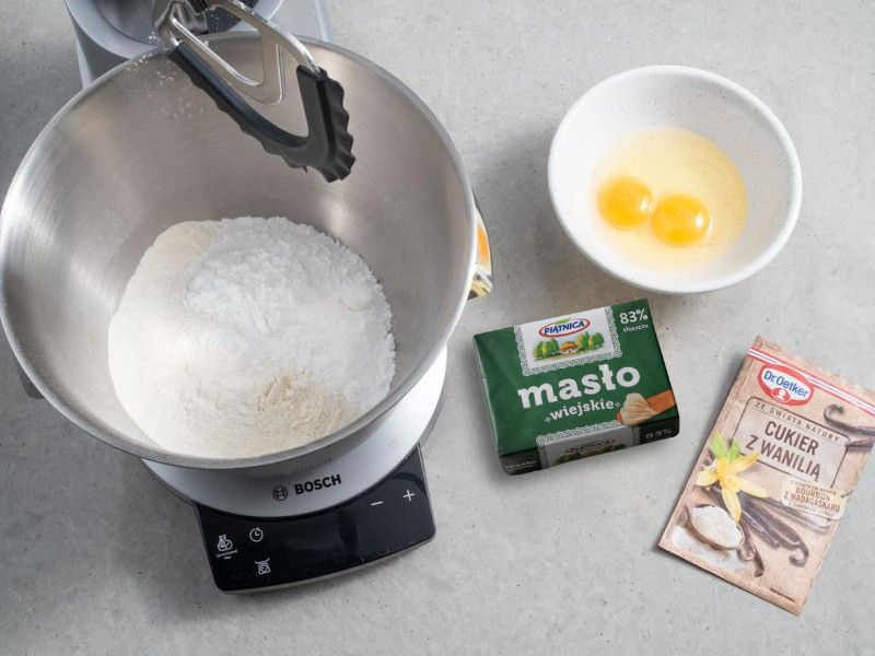 w misce robota bosch mąka Polka, na blacie masło Piątnica, cukier puder i proszek do pieczenia