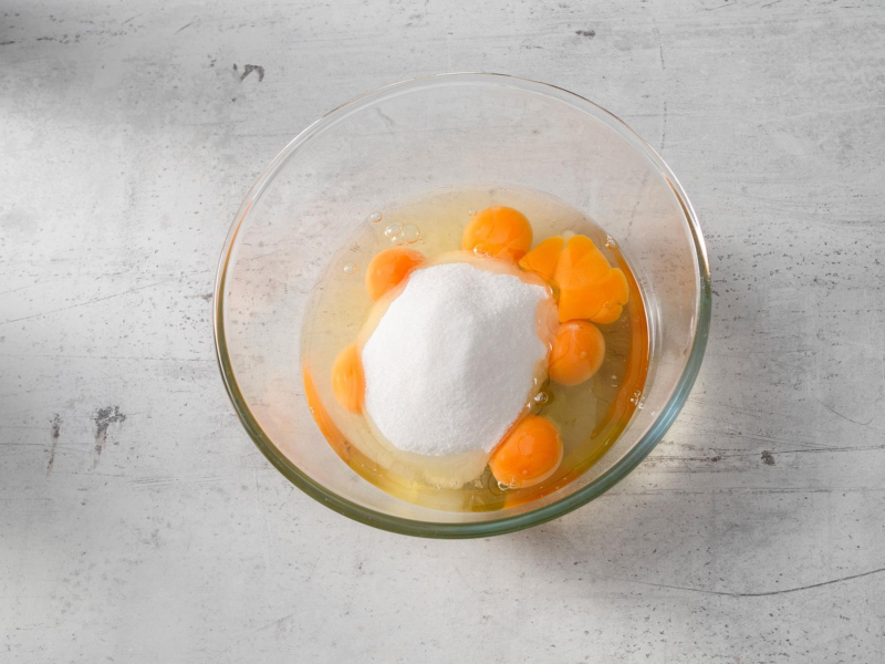 w szklanej misce wbite jajka i cukier