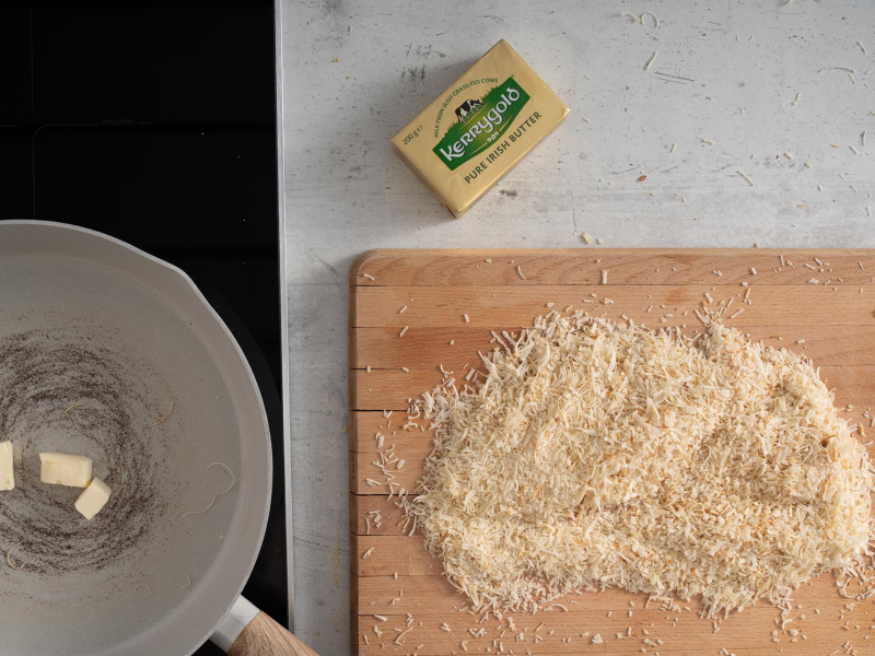 Ciasto kataifi na drewnianym blacie. Obok patelnia i masło.