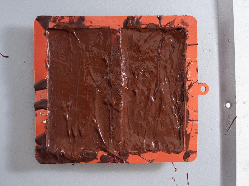 Masa pistacjowa z ciastem kataifi przykryta ostatnią warstwą czekolady.