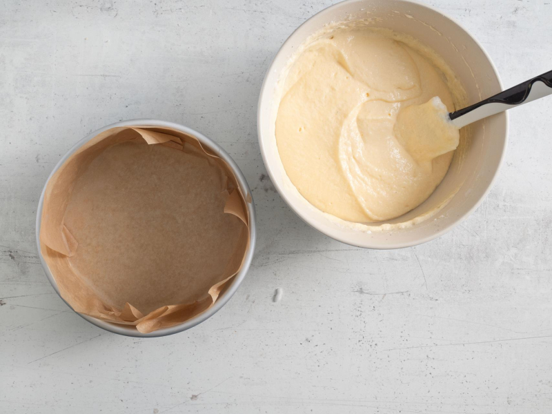 Foremka wy艂o偶ona papierem do pieczenia. Obok wymieszana masa na skyrnik.