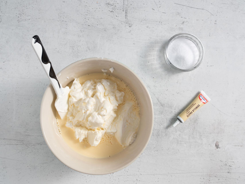 W misce napój proteinowy ze skyrem. Obok pasta waniliowa i ksylitol.