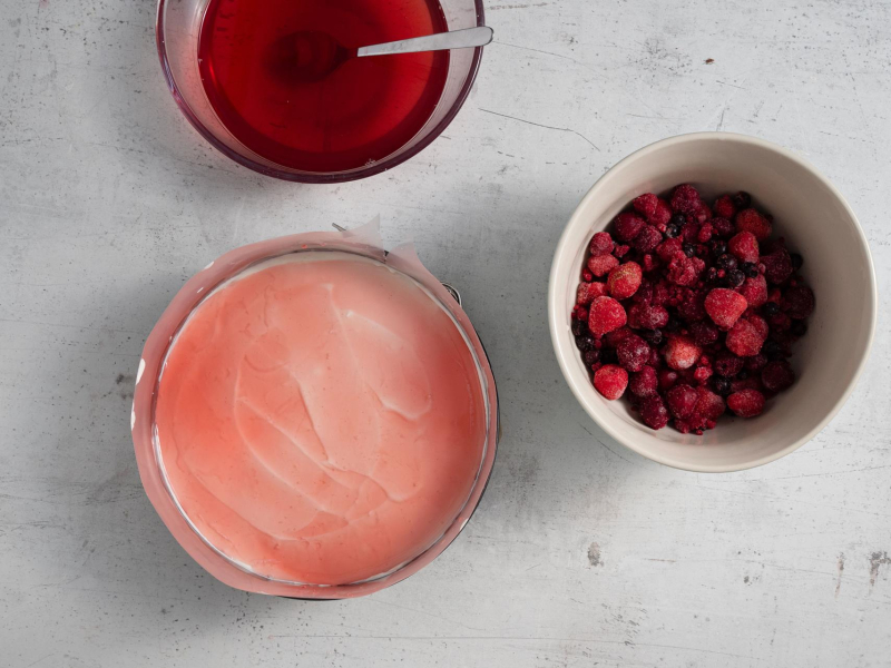 Forma z masą serową. Obok miseczka z galaretką i owocami.