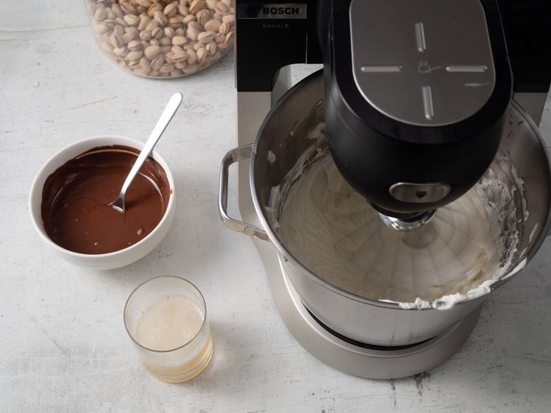 w robocie kuchennym bosch masa na sernik dubajski bez pieczenia, obok rozpuszczona czekolada i żelatyna