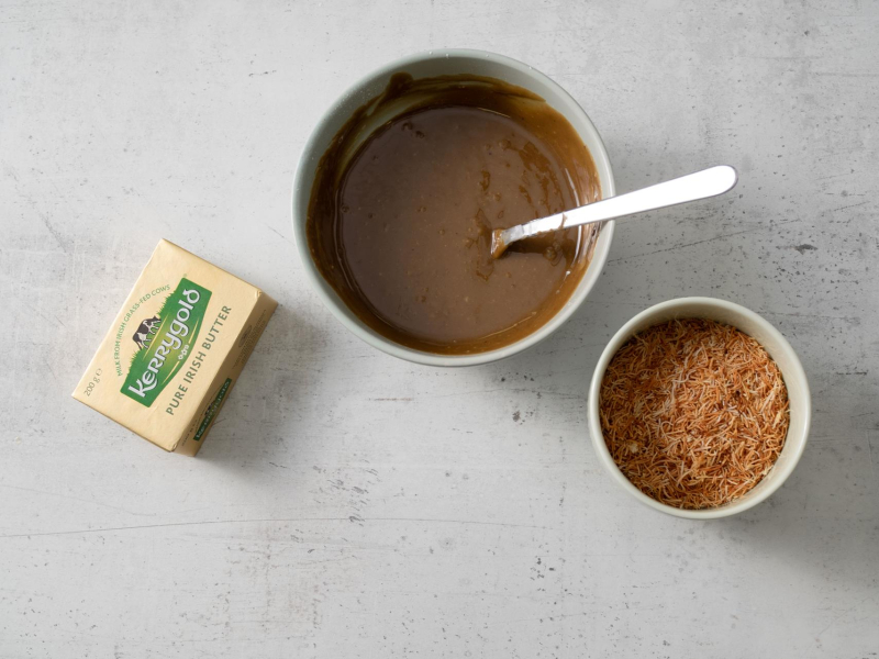 w miseczce masa pistacjowa obok uprażone ciasto kataifi