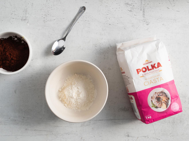 W miseczkach: mąka oraz kakao. Obok sól na łyżeczce,