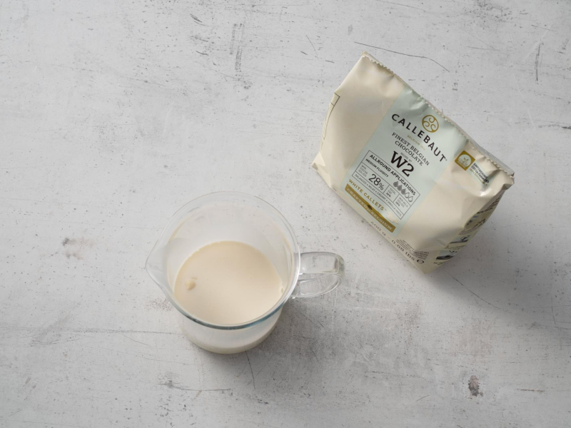 w szklanym naczyniu biała czekolada zalana śmietanką