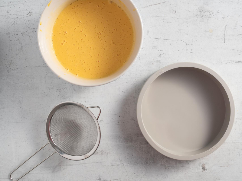 Na blacie forma silikonowa, obok sitko i masa jogurtowa w misie.