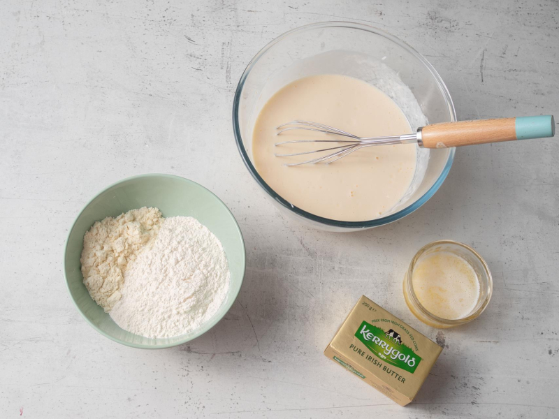 w miskach mokre i suche składniki na proteinowe gofry i roztopione masło Kerrygold w szklanej miseczce