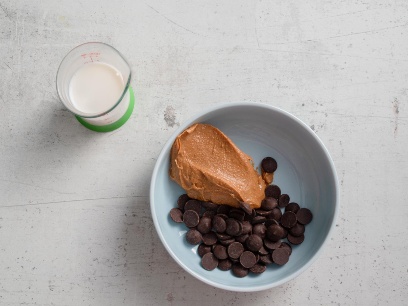 w naczyniu śmietanka, w miseczce czekolada i masło orzechowe