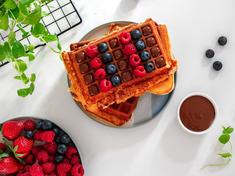 na talerzyku proteinowe gofry z owocami i sosem czekoladowym, na kratce mięta