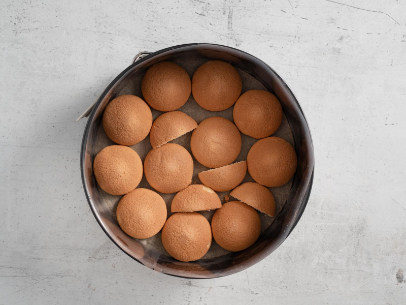 Ułożone biszkopty w tortownicy.