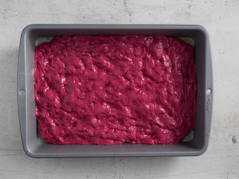 Różowe ciasto drożdżowe wyłożone w formie.